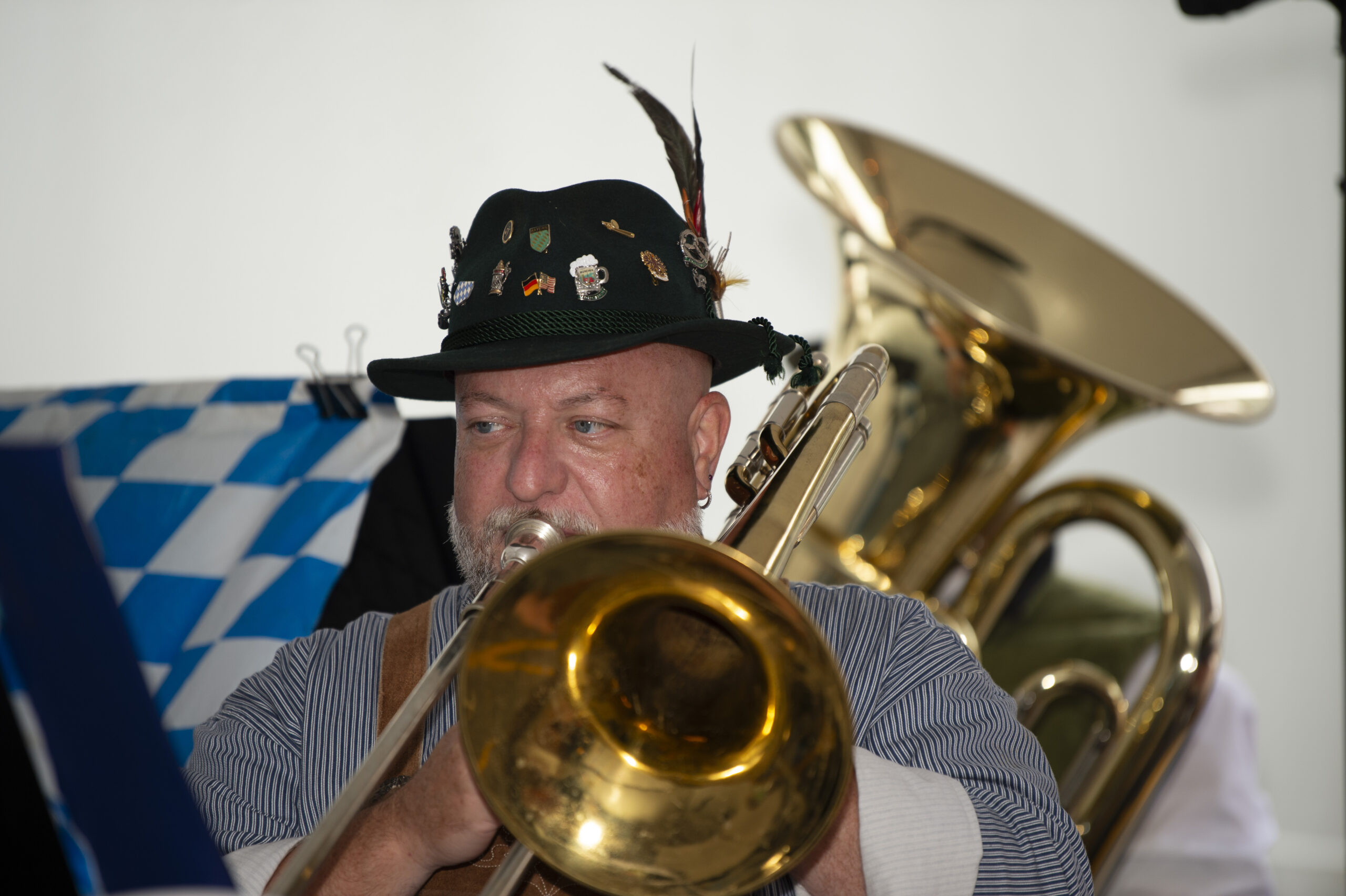 Man playing trombone with tuba in background