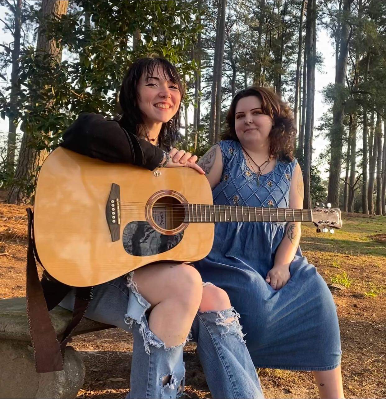 Folk duo After the Foxes in wooded setting with guitar