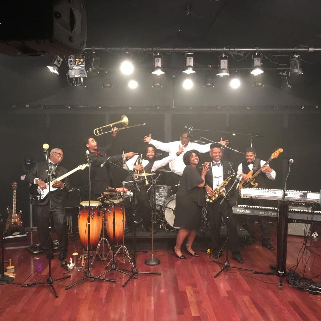 Band shot with members holding instruments in the air