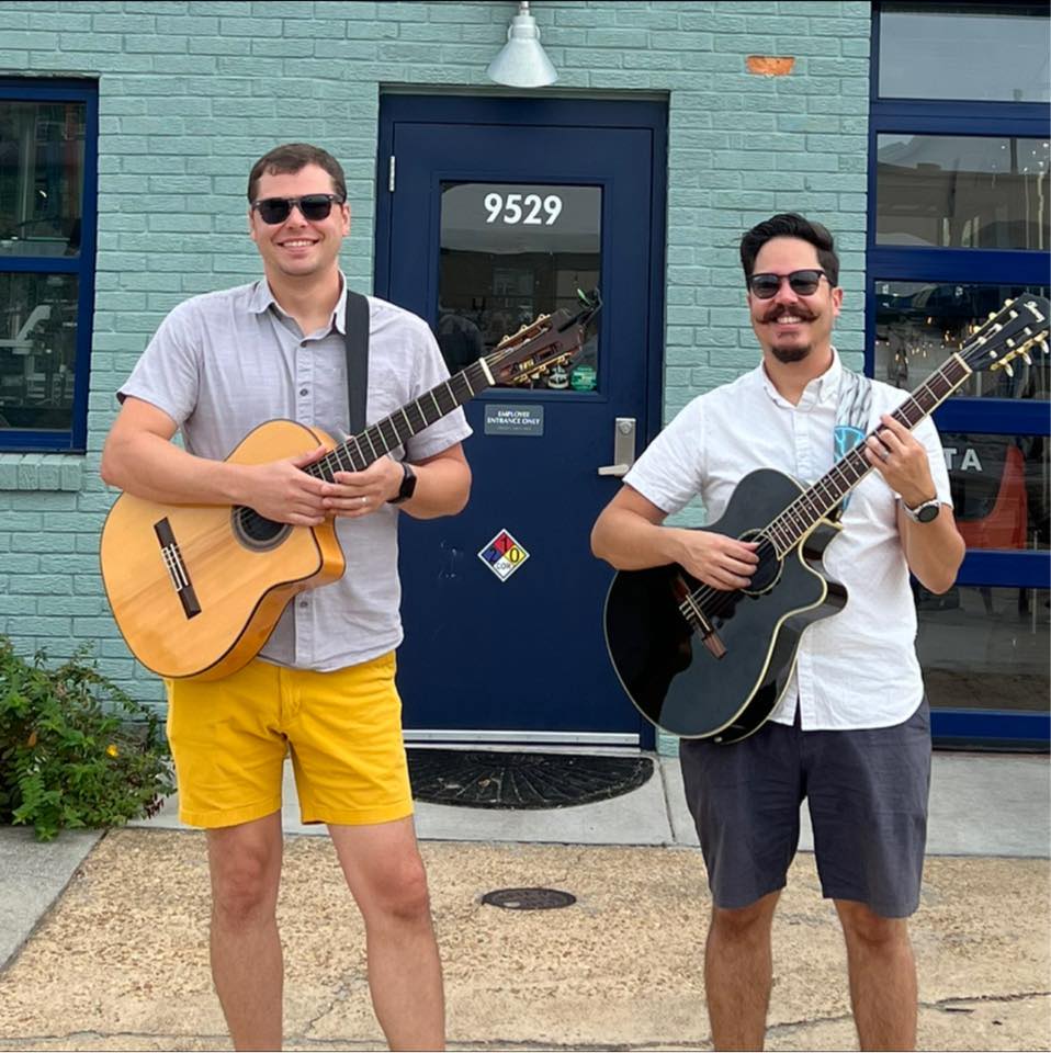 two men with guitars wearing shorts
