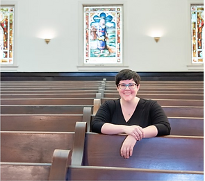 Dr. Amy Milligan seated on a pew