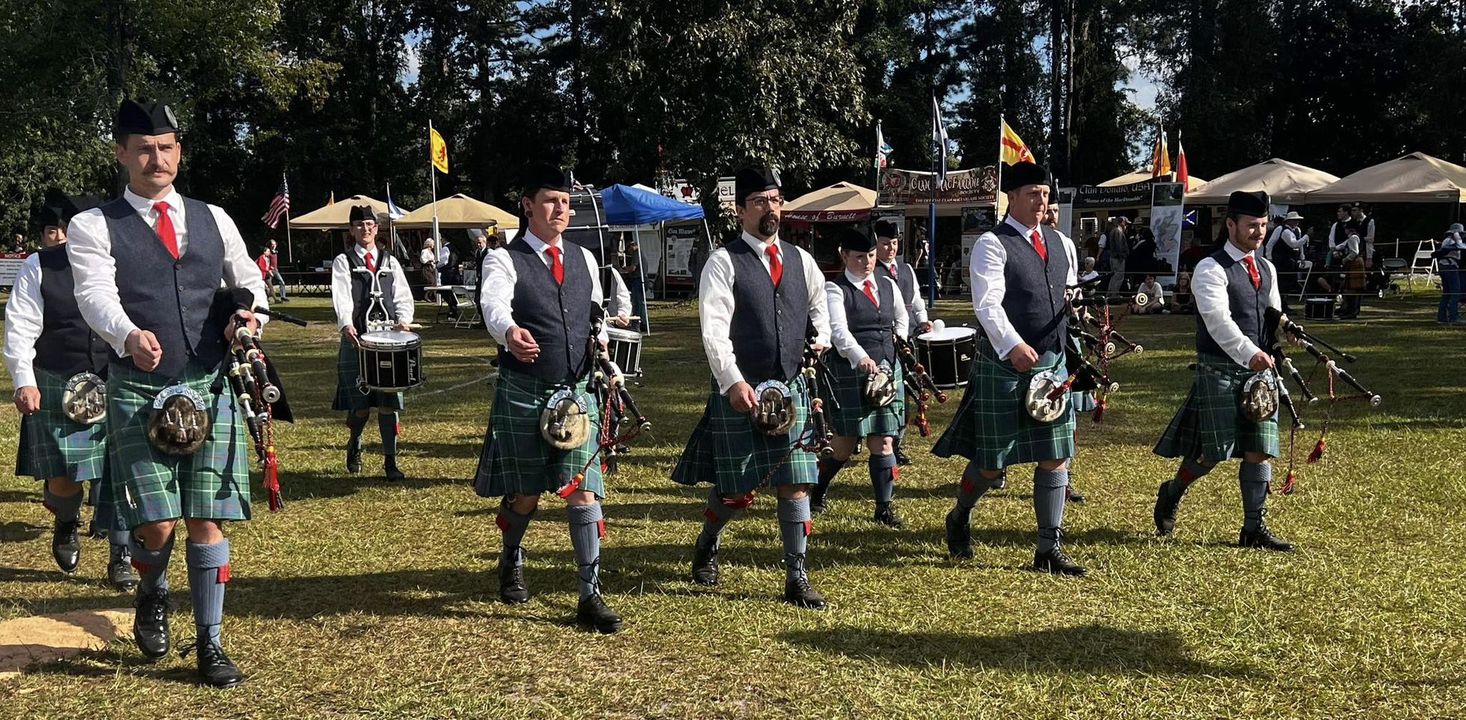 Siren City Pipe Band marching on grassy field