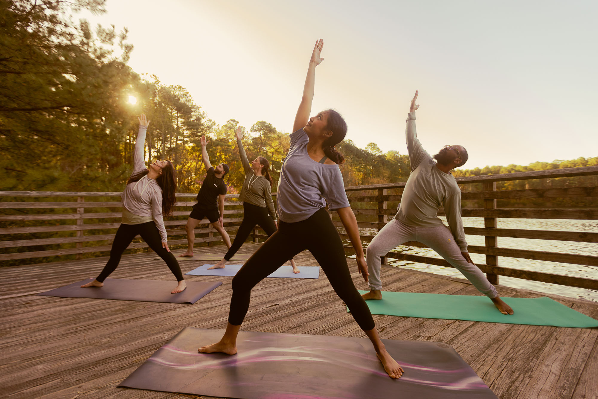 People in yoga poses at Lake Ballard