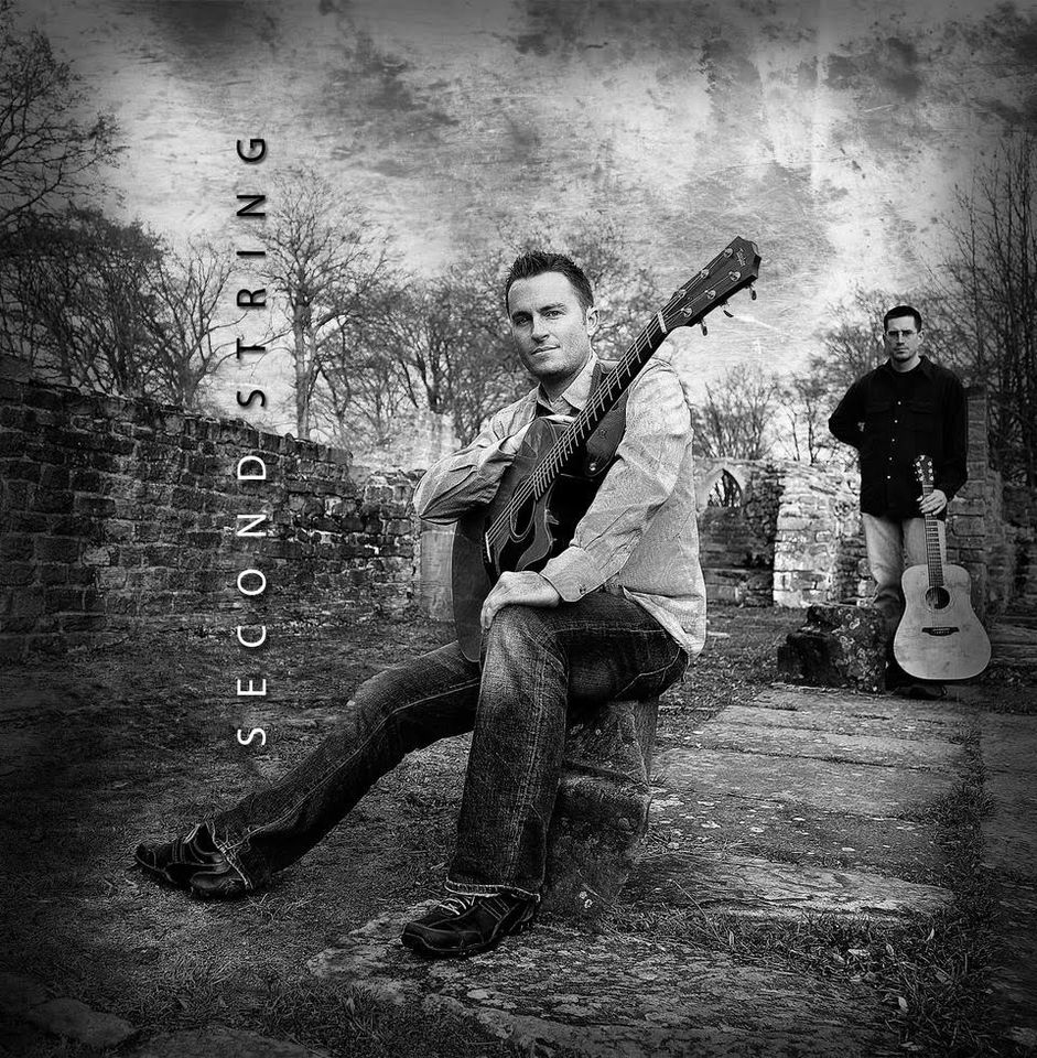 two guys posed with guitars in an distopean setting