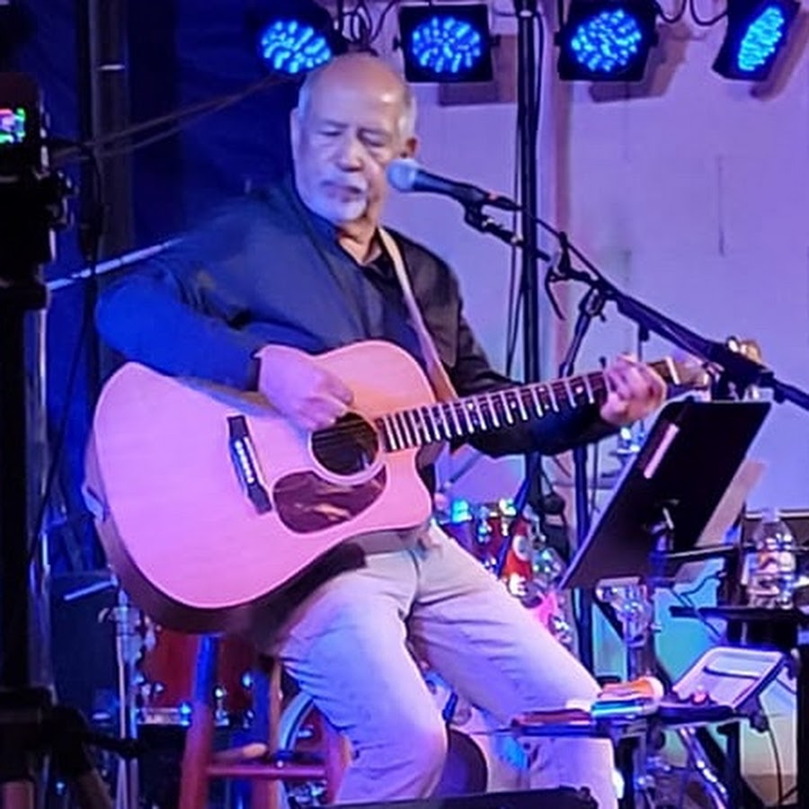 Richard Spano playing guitar and singing on stage