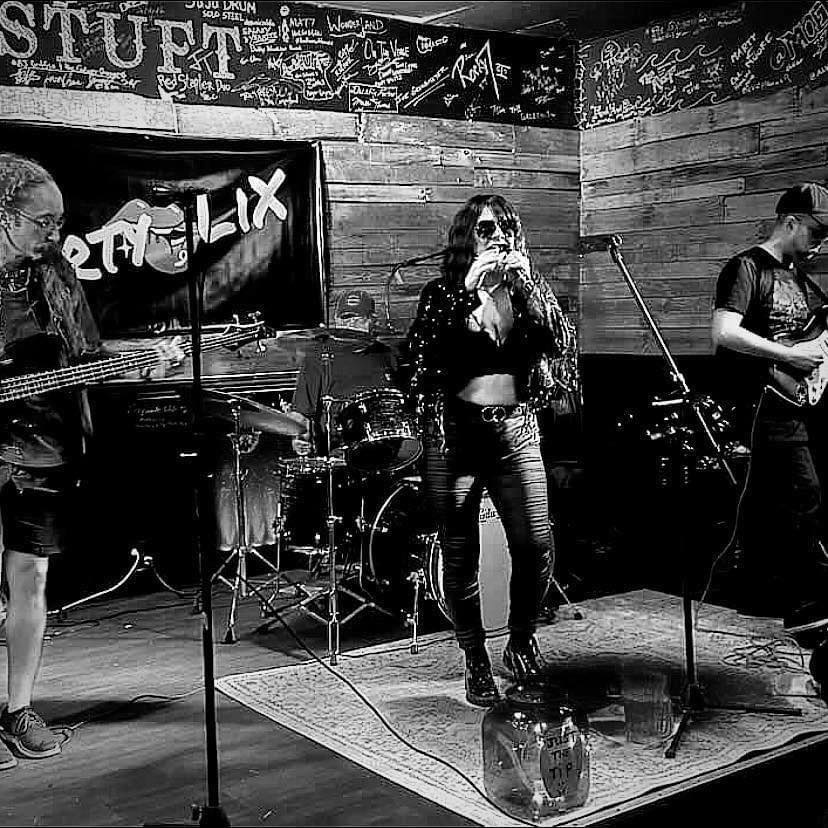 Trio on stage singing and playing guitar Dirty Lix